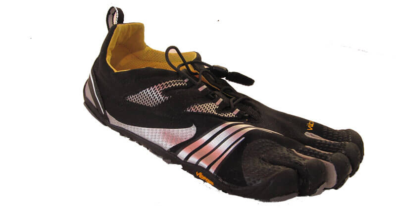 Zu sehen ist ein Zehenschuh von Vibram in schwarz, der vor mit weißen und silbernen Streifen verzeirt ist.