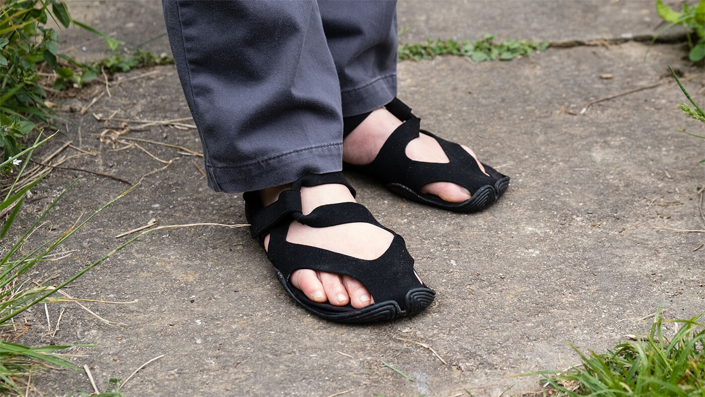 Ein Paar mit schwarzen Wilding Sandalen an meinen Füßen.